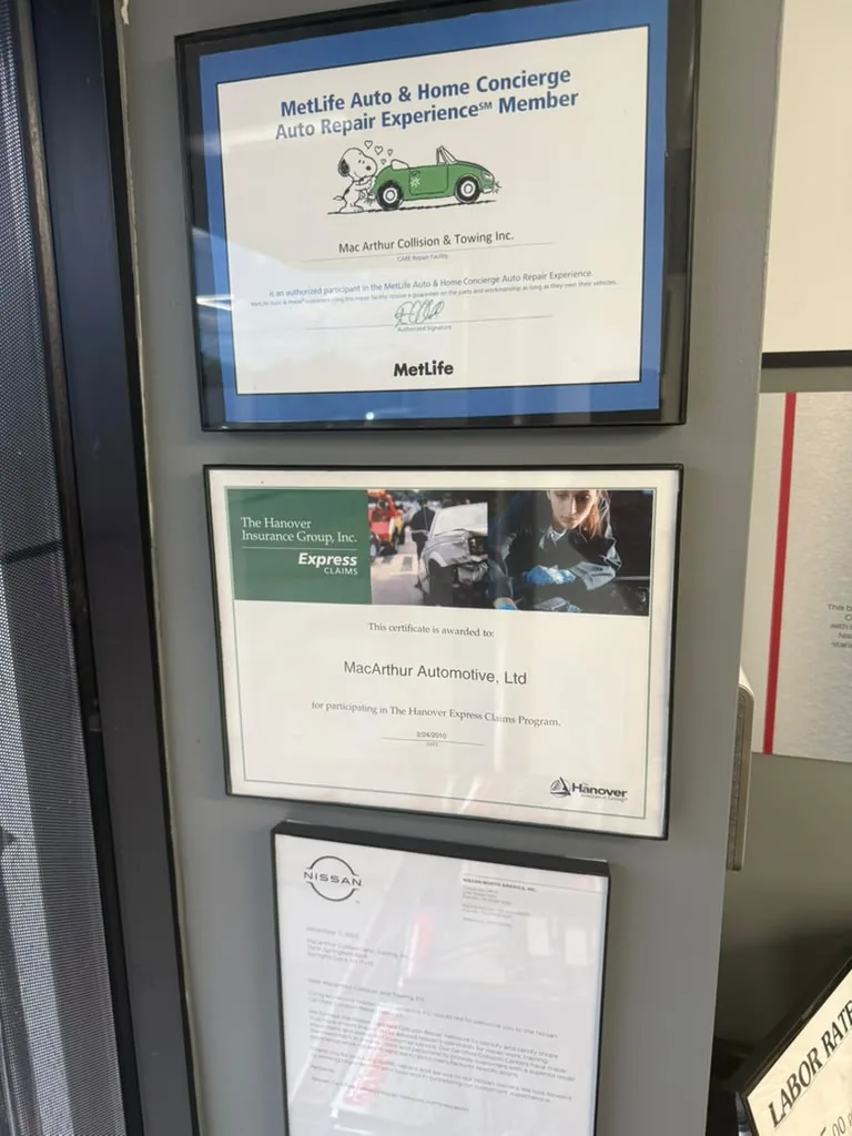 Shop wall displaying MetLife, Hanover, and Nissan certifications side by side